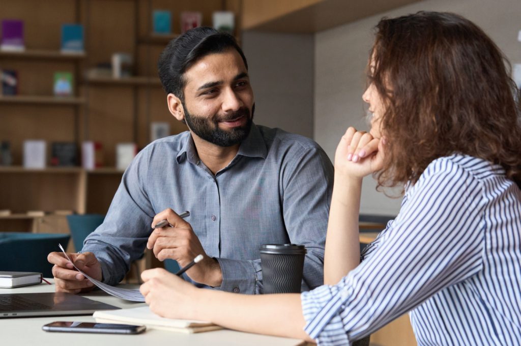 Smiling businesspeople discussing a document.