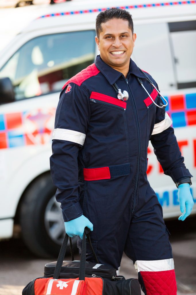 Smiling paramedic carrying portable equipment